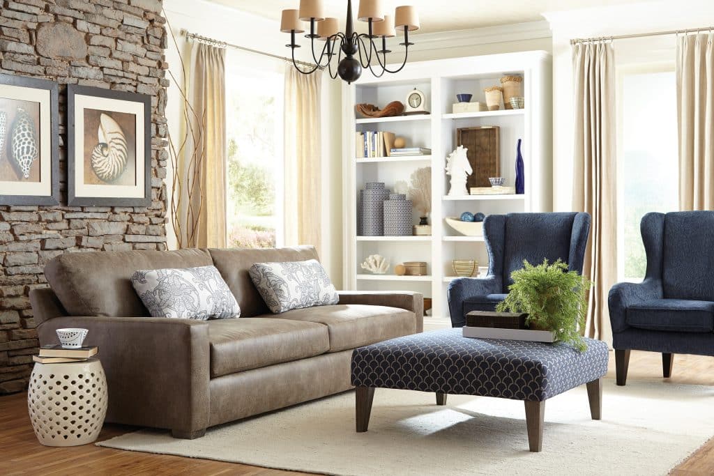 Modern and cozy living room with custom made sofa, accent chairs and upholstered ottoman pouf